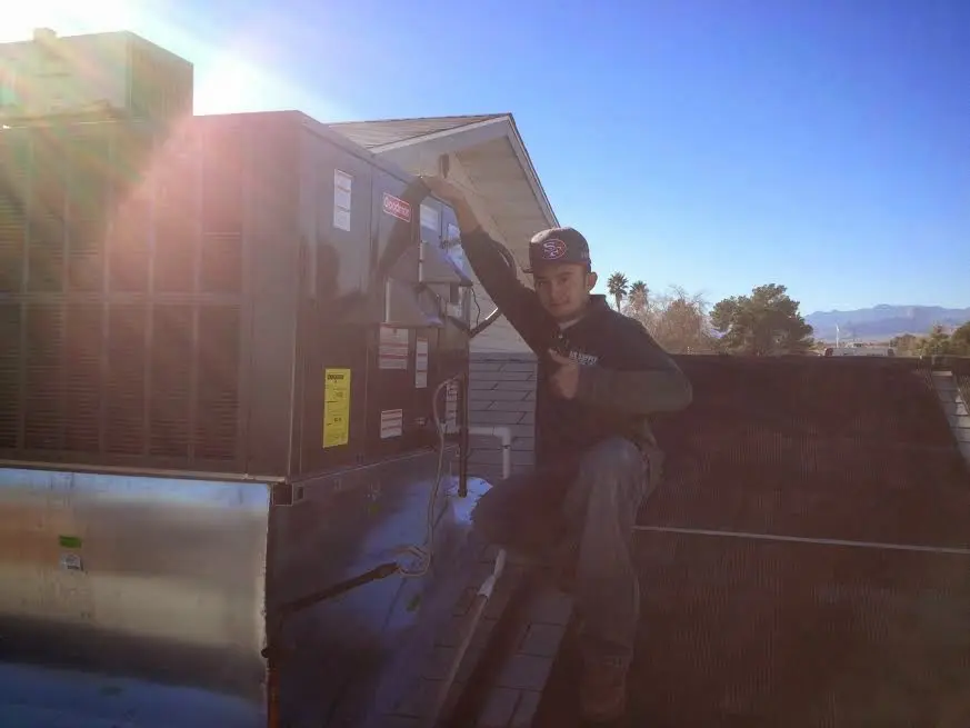 HVAC technician performing HVAC Inspection on a rooftop unit in Royal Oak